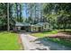 Charming home featuring a covered carport, a red front door, and a long driveway at 3195 Newcastle Way, Snellville, GA 30039