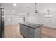 Open kitchen layout with a gray kitchen island, granite countertop, and hardwood floors at 3195 Newcastle Way, Snellville, GA 30039