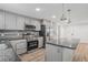 Updated kitchen with stainless steel appliances, gray cabinets, granite countertops, and stylish lighting at 3195 Newcastle Way, Snellville, GA 30039