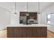 Modern kitchen with a large island, white countertops, wood cabinets, stainless steel appliances, and stylish pendant lighting at 367 Parkway Ne Dr # 7, Atlanta, GA 30312