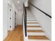 Modern staircase with light wood treads, white risers, and black metal railing at 367 Parkway Ne Dr # 7, Atlanta, GA 30312