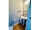 Powder room with pedestal sink, wood floors, oval mirror, and neutral paint at 5771 Vinings Retreat Sw Way, Mableton, GA 30126