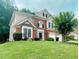 Charming two-story home with brick facade, landscaped yard, and a well-manicured lawn at 5771 Vinings Retreat Sw Way, Mableton, GA 30126
