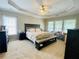 This is a large bedroom with a neutral color palette, tray ceiling, ceiling fan, and large windows at 5771 Vinings Retreat Sw Way, Mableton, GA 30126