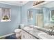Bright bathroom featuring a double sink vanity, a shower, a bathtub, and natural light from the window at 136 Fairlane Dr, Covington, GA 30016