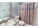 Bathroom with light blue walls, white sink, toilet, and decorative shower curtain at 136 Fairlane Dr, Covington, GA 30016