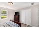 Bedroom features a large closet, hardwood floors, window with backyard view, and TV on dresser at 136 Fairlane Dr, Covington, GA 30016
