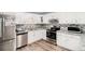 Modern kitchen featuring white cabinets, stainless steel appliances, and a sleek backsplash at 136 Fairlane Dr, Covington, GA 30016