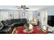 Spacious living room featuring a comfortable sectional, unique decor, and a ceiling fan at 136 Fairlane Dr, Covington, GA 30016
