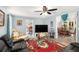Open concept living room with ceiling fan, hardwood floors, and furniture facing a large TV at 136 Fairlane Dr, Covington, GA 30016