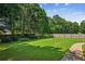 Spacious backyard with a fire pit, bordered by mature trees and a wooden fence, offers privacy and outdoor enjoyment at 1506 Threepine Place Pl, Lilburn, GA 30047