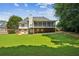 Picturesque backyard featuring a raised screened porch overlooking a large lawn, perfect for outdoor living and entertaining at 1506 Threepine Place Pl, Lilburn, GA 30047