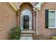 Elegant arched front door with sidelights, set within a classic brick facade, enhances the home's entry at 1506 Threepine Place Pl, Lilburn, GA 30047