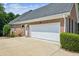 Spacious two-car garage with ample parking space, set against a well-kept brick exterior and landscaped surroundings at 1506 Threepine Place Pl, Lilburn, GA 30047