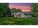 Evening shot of a large backyard with green grass, screened in porch, and wooden deck at 5148 Coolamber Dr, Powder Springs, GA 30127