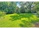 A lush backyard with a large lawn and mature trees offers a private and serene outdoor space at 5148 Coolamber Dr, Powder Springs, GA 30127