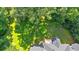 Aerial view of a backyard with a lush lawn and mature trees, showcasing a wooden deck accessible from the home at 5148 Coolamber Dr, Powder Springs, GA 30127