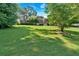 Expansive front yard showcases a well-maintained lawn and mature trees surrounding a brick two-story home at 5148 Coolamber Dr, Powder Springs, GA 30127