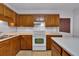Galley kitchen features wood cabinets, white countertops and white appliances at 5148 Coolamber Dr, Powder Springs, GA 30127
