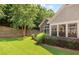 The landscaped backyard features a retaining wall, lush lawn, and vibrant greenery around the home at 6042 Brookhaven Cir # 3202, Johns Creek, GA 30097