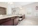 Bathroom with granite countertops, double sinks, tiled floors and large frameless mirror at 6042 Brookhaven Cir # 3202, Johns Creek, GA 30097