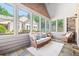Bright sunroom with stone accent wall, comfortable seating and large windows with natural light at 6042 Brookhaven Cir # 3202, Johns Creek, GA 30097
