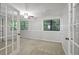 Bright bedroom featuring neutral carpeting, paneled walls, windows, and french doors at 68 La Rue Nw Pl, Atlanta, GA 30327