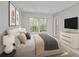 Comfortable bedroom features natural light, a dresser with a TV, and a plush upholstered bed at 68 La Rue Nw Pl, Atlanta, GA 30327