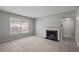 A living room featuring neutral walls, carpeting, a fireplace, and natural light from the window at 68 La Rue Nw Pl, Atlanta, GA 30327