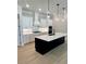 Well-lit kitchen with a large island, stainless steel appliances, and sleek pendant lighting at 7220 Winderlea Ln, Cumming, GA 30040