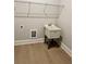 Well-lit laundry room featuring a utility sink, wooden floors, and convenient shelving at 7220 Winderlea Ln, Cumming, GA 30040