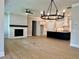 Spacious living room with fireplace and hardwood floors that seamlessly flows into a modern kitchen at 7220 Winderlea Ln, Cumming, GA 30040