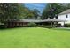 Single-story brick home featuring lush green lawn, mature trees, and a two-car carport at 742 Starlight Ne Ct, Sandy Springs, GA 30342
