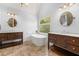 Bathroom features dual vanities and standalone tub with tile floors and mirrors at 4345 Mantle Ridge Dr, Cumming, GA 30041