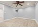 Neutral carpeted bedroom showcasing ceiling fan, overhead lighting, and white trim throughout at 4345 Mantle Ridge Dr, Cumming, GA 30041