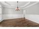 Formal dining room featuring hardwood floors, wainscoting, a decorative chandelier and crown molding at 4345 Mantle Ridge Dr, Cumming, GA 30041