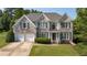 Charming two-story brick home with a well-manicured lawn, two-car garage and attractive shutters at 4345 Mantle Ridge Dr, Cumming, GA 30041