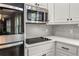 Kitchen features stainless steel microwave and cooktop with white cabinets at 4345 Mantle Ridge Dr, Cumming, GA 30041