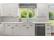 Kitchen features white cabinets, stainless steel sink, and tiled backsplash at 4345 Mantle Ridge Dr, Cumming, GA 30041