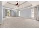 Spacious main bedroom with tray ceiling, ceiling fan, carpet, and curtains at 4345 Mantle Ridge Dr, Cumming, GA 30041