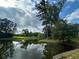 Picturesque community pond reflecting the sky, surrounded by lush greenery and trees at 506 Spring View Dr, Woodstock, GA 30188