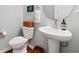 Elegant powder room featuring a pedestal sink, round mirror, and neutral decor at 506 Spring View Dr, Woodstock, GA 30188