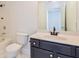 Bathroom featuring a vanity with dark cabinets, white sink and toilet, and a shower-tub combination at 5900 Fairington Farms Lane Ln, Stonecrest, GA 30038