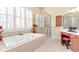 Elegant bathroom showcasing a soaking tub, glass-enclosed shower, and natural light at 8095 Georgetown Cir, Suwanee, GA 30024