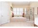 Bright bathroom featuring a soaking tub, glass-enclosed shower, and tiled floors at 8095 Georgetown Cir, Suwanee, GA 30024