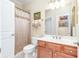Bathroom with vanity, toilet, and shower featuring tiled walls and floors at 8095 Georgetown Cir, Suwanee, GA 30024
