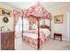 Charming bedroom with four-poster bed and coordinated red and white decor, for a cozy, elegant feel at 8095 Georgetown Cir, Suwanee, GA 30024