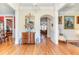 Elegant foyer featuring hardwood floors, a decorative mirror, and arched doorway leading to the living area at 8095 Georgetown Cir, Suwanee, GA 30024