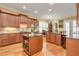 Well-equipped kitchen with wood cabinets, granite counters, and a center island with storage at 8095 Georgetown Cir, Suwanee, GA 30024