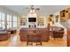 Bright living room featuring built-in shelves, large windows, and stylish leather furniture at 8095 Georgetown Cir, Suwanee, GA 30024